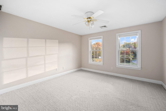 carpeted spare room featuring ceiling fan