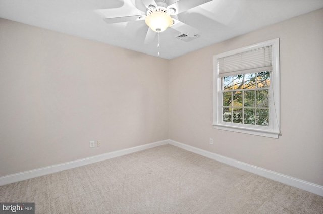 carpeted spare room with ceiling fan