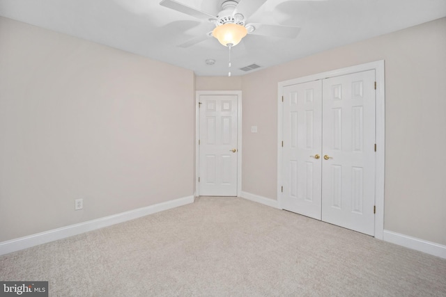 unfurnished bedroom with light carpet, ceiling fan, and a closet