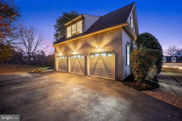 view of garage at dusk