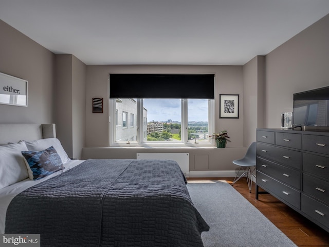 bedroom featuring dark hardwood / wood-style flooring and radiator heating unit