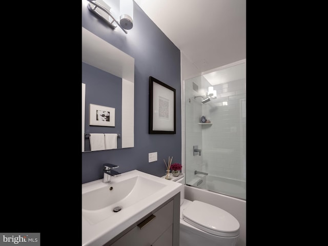 full bathroom featuring toilet, vanity, and bath / shower combo with glass door