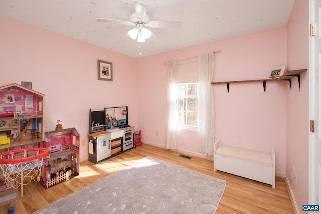 playroom with hardwood / wood-style flooring and ceiling fan