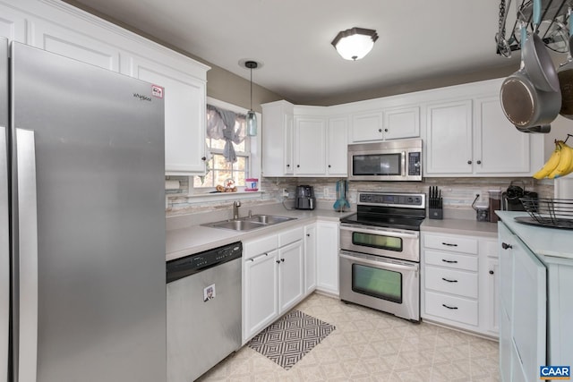 kitchen with stainless steel appliances, white cabinetry, sink, and decorative light fixtures