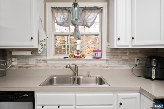 kitchen with decorative backsplash, white cabinetry, sink, and dishwashing machine