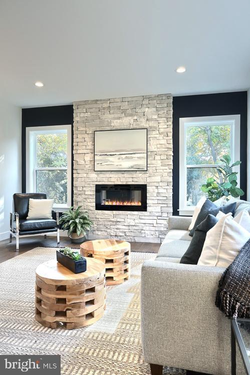 living room featuring a fireplace, healthy amount of natural light, recessed lighting, and wood finished floors