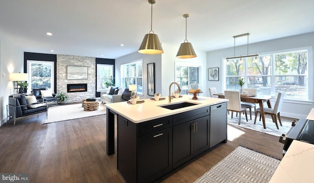 kitchen featuring stainless steel dishwasher, a wealth of natural light, sink, and pendant lighting