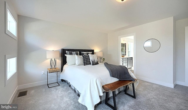 bedroom featuring light colored carpet and connected bathroom