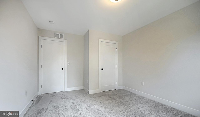 unfurnished bedroom featuring light carpet and a closet