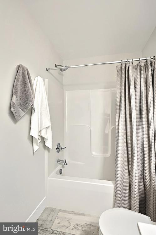 bathroom with toilet and shower / tub combo