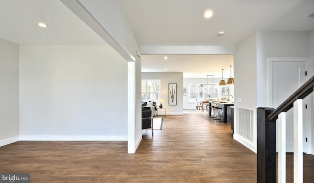 hallway featuring wood finished floors, recessed lighting, and baseboards