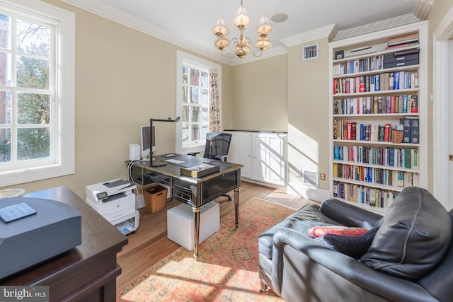 office space featuring a chandelier, ornamental molding, and light hardwood / wood-style flooring