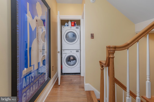 laundry area featuring stacked washer and dryer and light hardwood / wood-style floors