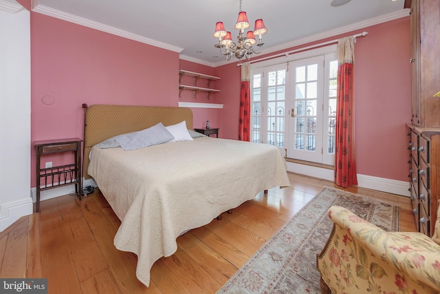 bedroom with french doors, light hardwood / wood-style floors, an inviting chandelier, and crown molding