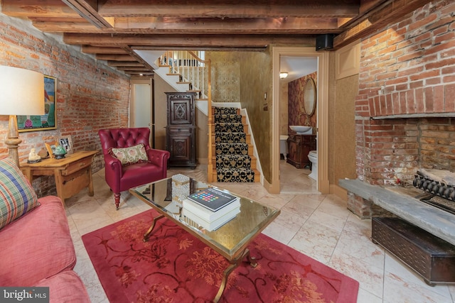 living room featuring beam ceiling and brick wall