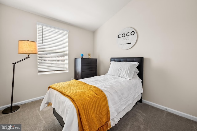 bedroom with vaulted ceiling and dark colored carpet