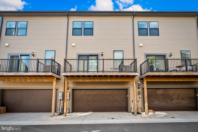 rear view of property with a garage and a balcony