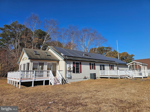 back of property featuring central AC, a yard, and a wooden deck