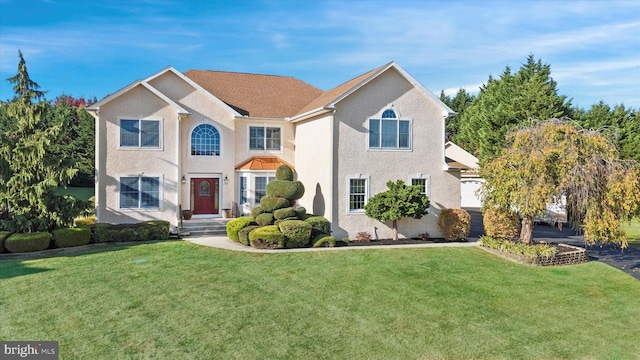 view of front of property featuring a front lawn and stucco siding