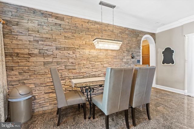 dining room featuring baseboards, arched walkways, granite finish floor, and ornamental molding