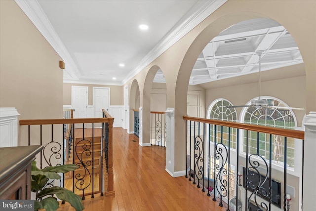 hall featuring light wood-style flooring, a healthy amount of sunlight, ornamental molding, and recessed lighting