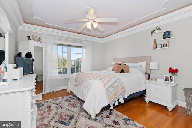 bedroom with ornamental molding, baseboards, a ceiling fan, and wood finished floors