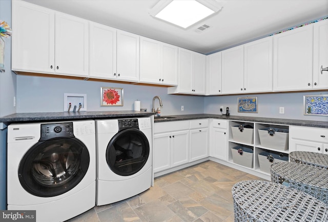laundry area with stone finish floor, visible vents, independent washer and dryer, cabinet space, and a sink