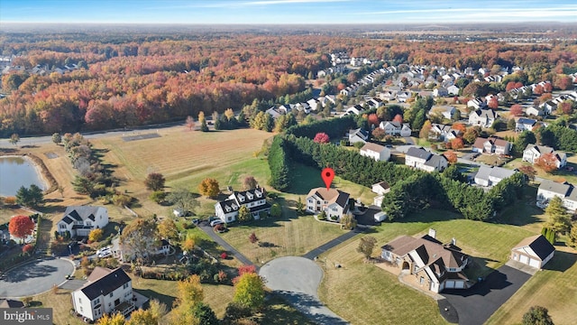 bird's eye view with a wooded view and a residential view