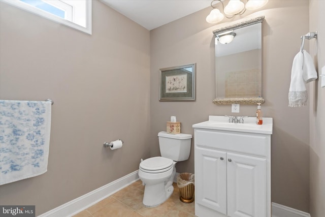 bathroom with toilet, tile patterned flooring, baseboards, and vanity