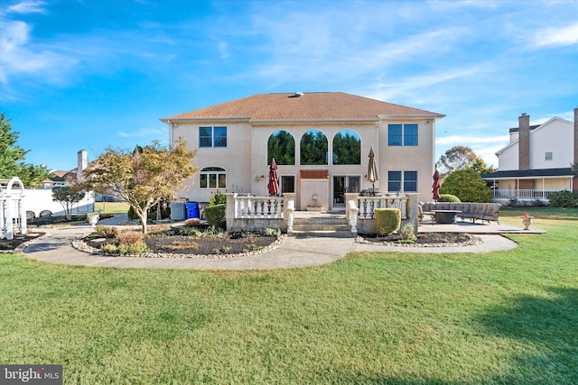 back of property with central AC, a yard, a patio area, an outdoor living space, and stucco siding