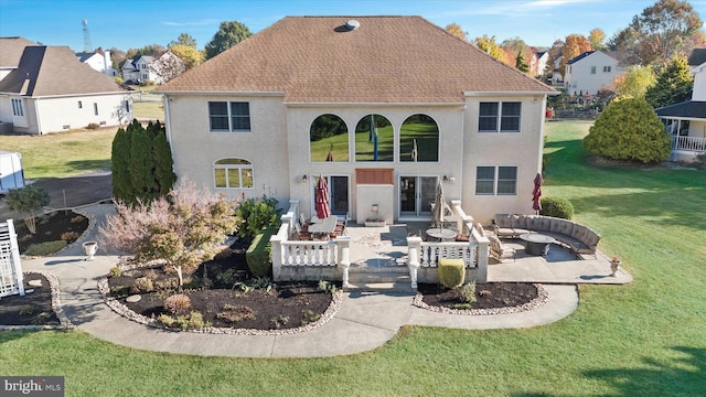 rear view of property featuring outdoor lounge area, a yard, stucco siding, a patio, and a shingled roof
