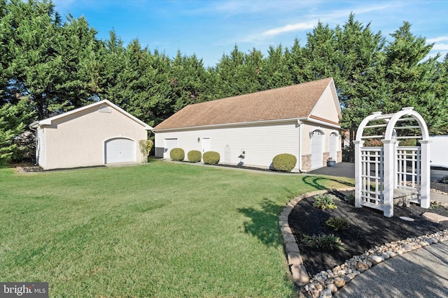 view of yard with a detached garage and an outdoor structure