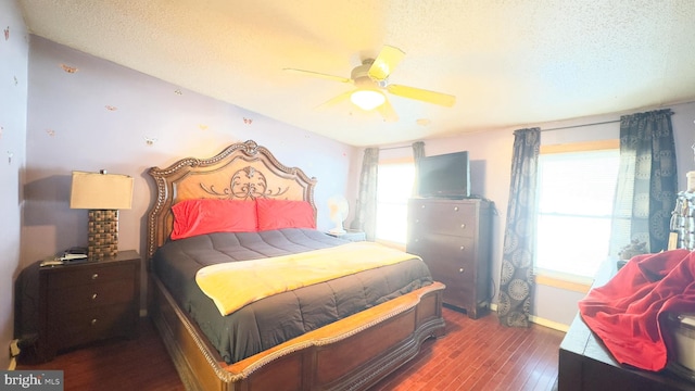 bedroom with ceiling fan, dark hardwood / wood-style floors, and a textured ceiling