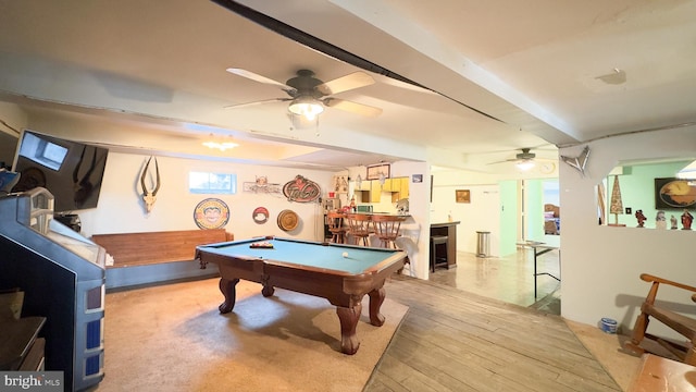 game room featuring bar area, billiards, ceiling fan, beam ceiling, and light wood-type flooring