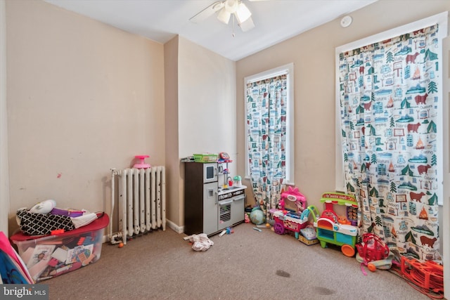 playroom with ceiling fan, radiator heating unit, and carpet floors