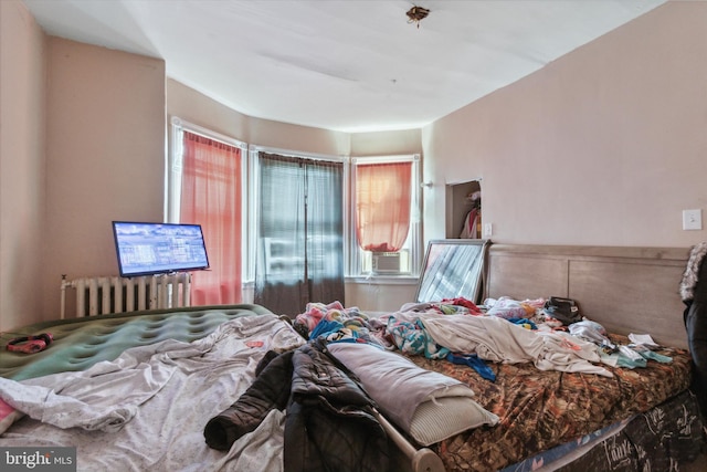 bedroom featuring radiator heating unit and cooling unit