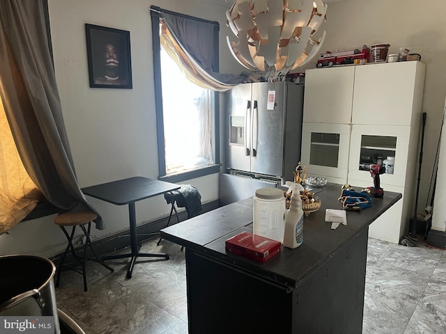 kitchen with stainless steel fridge and an inviting chandelier