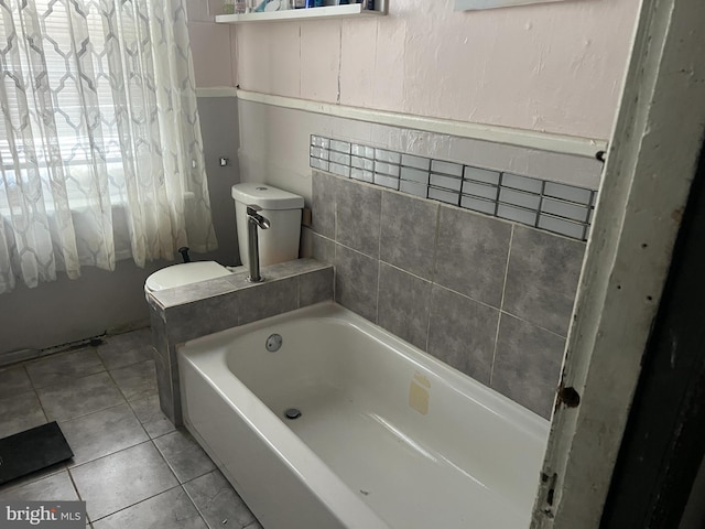 bathroom with toilet, tile patterned floors, and a bathing tub