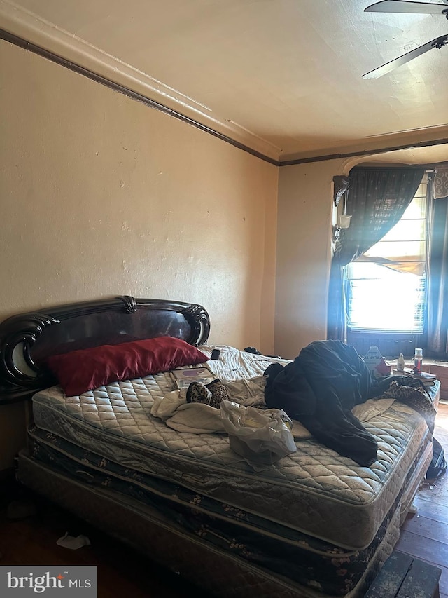 bedroom featuring hardwood / wood-style flooring, ceiling fan, and ornamental molding