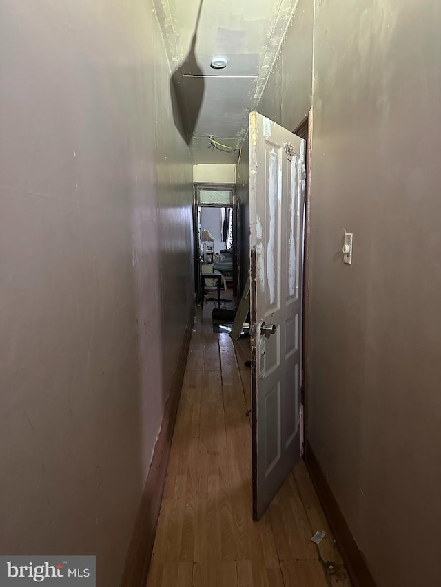 corridor with hardwood / wood-style flooring