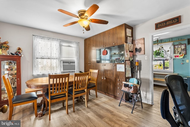 dining space featuring light hardwood / wood-style floors, cooling unit, a healthy amount of sunlight, and ceiling fan