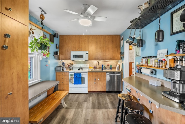 kitchen with dark hardwood / wood-style flooring, hanging light fixtures, sink, ceiling fan, and white appliances