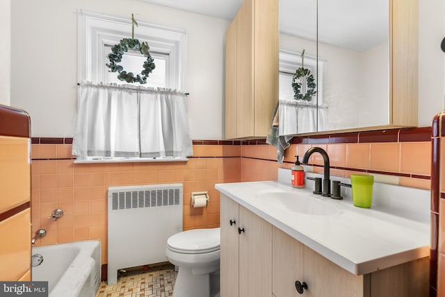 bathroom featuring tile walls, radiator heating unit, vanity, and toilet