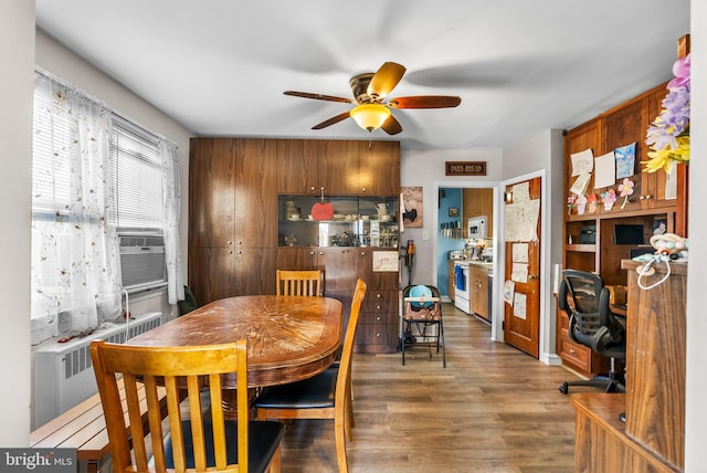 dining room with dark hardwood / wood-style flooring, radiator, cooling unit, and ceiling fan