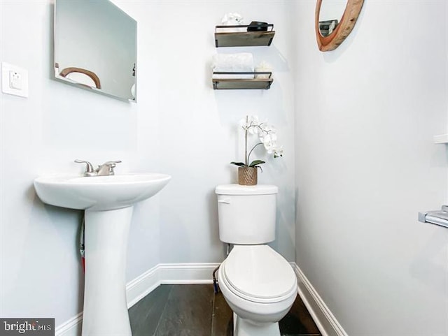 bathroom with hardwood / wood-style flooring, sink, and toilet