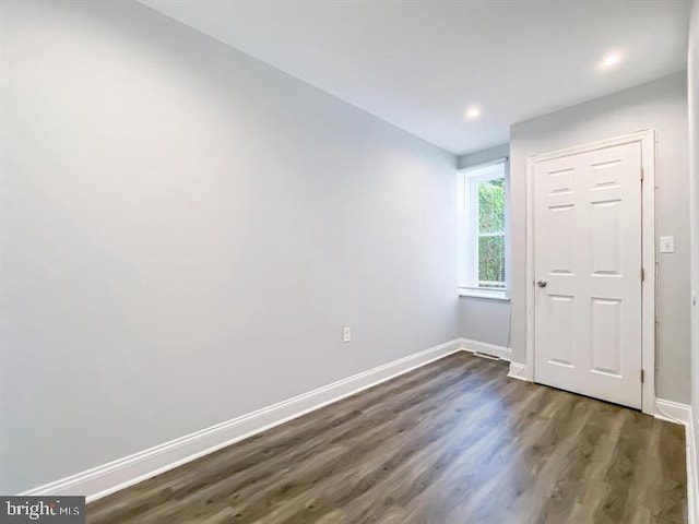 unfurnished room with dark wood-type flooring