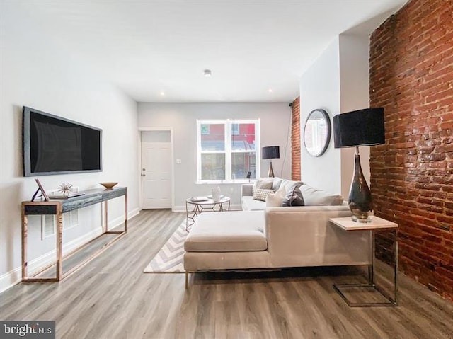 living room with wood-type flooring and brick wall