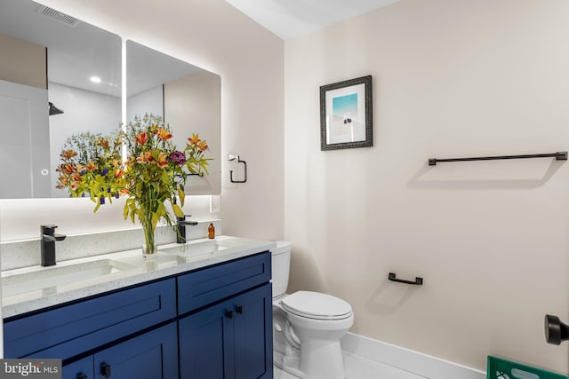 bathroom with tile patterned flooring, vanity, and toilet