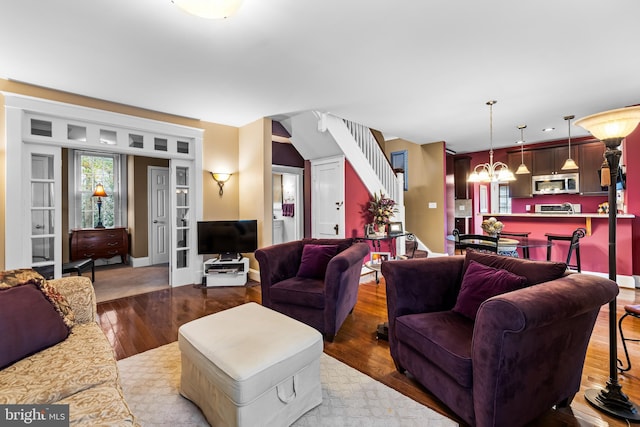 living room with a notable chandelier and hardwood / wood-style flooring