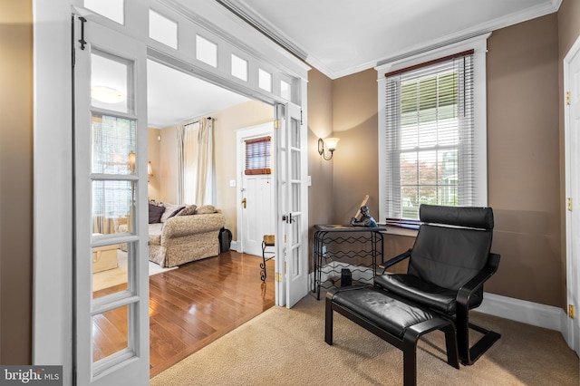 sitting room with hardwood / wood-style floors, ornamental molding, and french doors